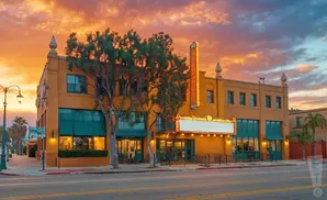 Orange theater building with marquee at sunset.