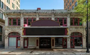 Exterior of a vintage movie theater with a marquis and ornate stonework.