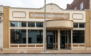 A beige commercial building with a light yellow brick facade and large windows.