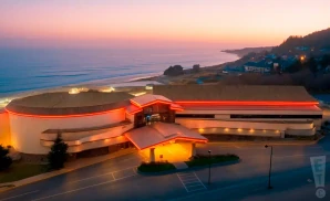 promotional exterior photograph of chinook winds casino resort, taken at sunset along the oregon coast. 