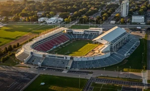 a hyper-realistic wide-angle aerial photograph of seatgeek stadium in bridgeview, illinois, captured at sunset. 