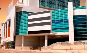 a promotional exterior photograph of the colosseum at caesars windsor in windsor, ontario, canada, taken at sunset under a vibrant, golden-orange sky.
