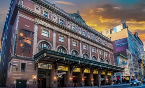 an exterior promotional venue picture of town hall theatre ny with a sunset sky