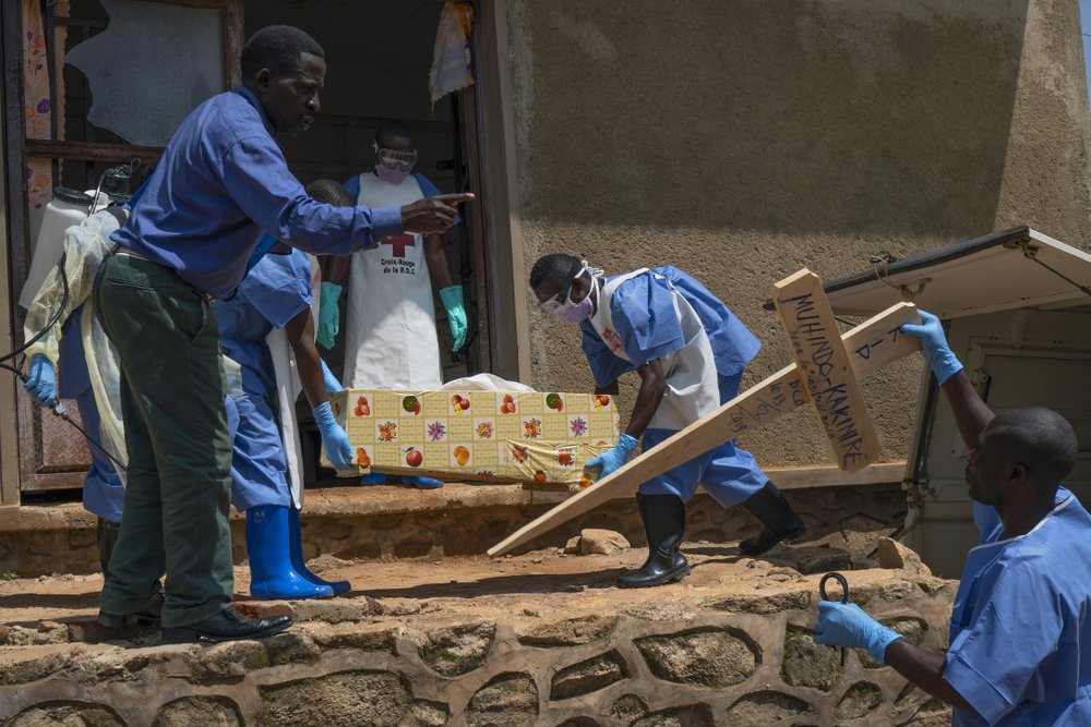 In this Sunday, July 14, 2019 photo, Red Cross workers carry the remains of 16-month-old Muhindo Kakinire from the morgue into a truck as health workers disinfect the area in Beni, Congo. The World Health Organization has declared the Ebola outbreak an international emergency. (AP Photo/Jerome Delay) | FACTSWANTED In this Sunday, July 14, 2019 photo, Red Cross workers carry the remains of 16-month-old Muhindo Kakinire from the morgue into a truck as health workers disinfect the area in Beni, Congo. The World Health Organization has declared the Ebola outbreak an international emergency. (AP Photo/Jerome Delay) | FACTSWANTED