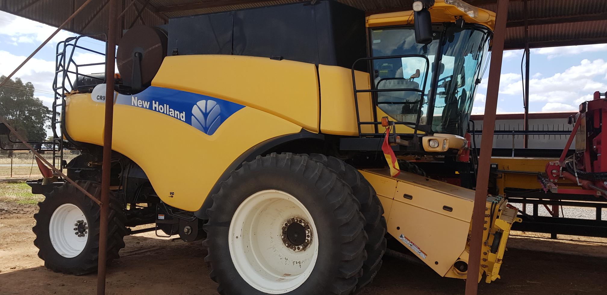 New Holland CR970A Header plus 45 feet honey bee front on trailer.