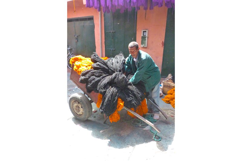 After the yarn is dyed, it is transported to the weaver by this man.