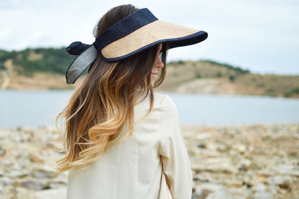 Woman in straw hat looks out across the water