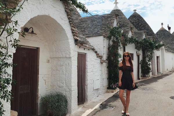 Victoria Lewis next to trulli huts in Alberobello.