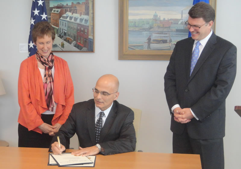 GSA Chief People Officer Anthony Costa signs the new telework agreement as GSA Administrator Martha Johnson and Office of Personnel Management Director John Berry look on today at GSA’s headquarters. 2011_10_telework1