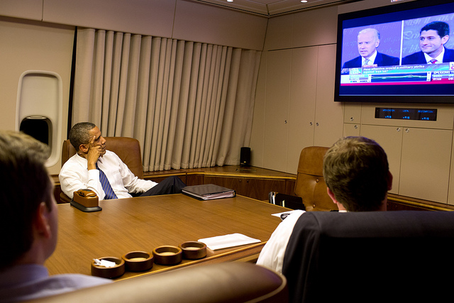 President Barack Obama watches the Vice Presidential debate aboard Air Force One with staff, en route to Joint Base Andrews, Maryland, from Florida, Oct. 11, 2012. (Official White House Photo by Pete Souza) 2012_10_8078825656_260c65a385_z