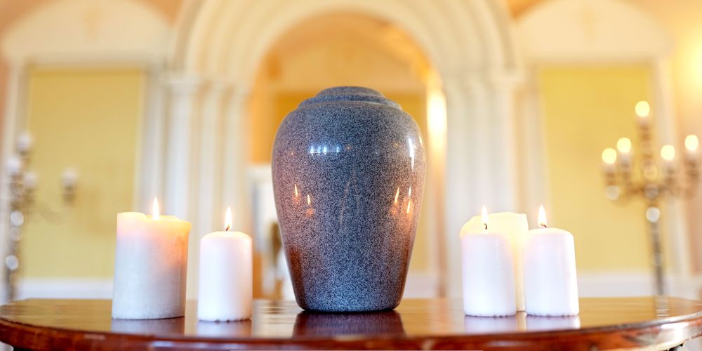 Decorative cremation urn surrounded by lit candles inside a chapel at Funeral Home and Cremations in New Berlin, WI.