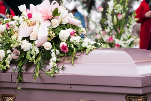 A casket decorated with pink and white flowers symbolizes remembrance and love in Middletown, NJ.
