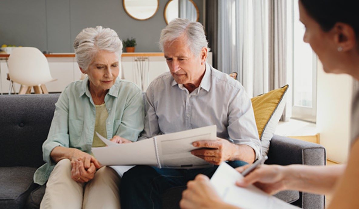 Couple on the couch reviewing paperwork, possibly planning funeral services in Middletown, NJ.