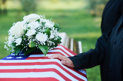 A person gently places a flower-adorned casket in the chapel at the funeral home in Middletown, NJ.