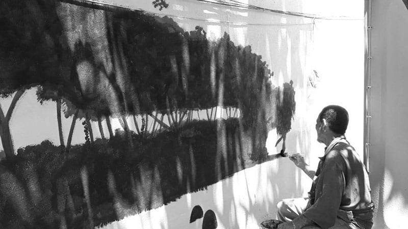 Refugiado pinta um mural, em projeto de arte e educação para refugiados, da FFHI em Roraima