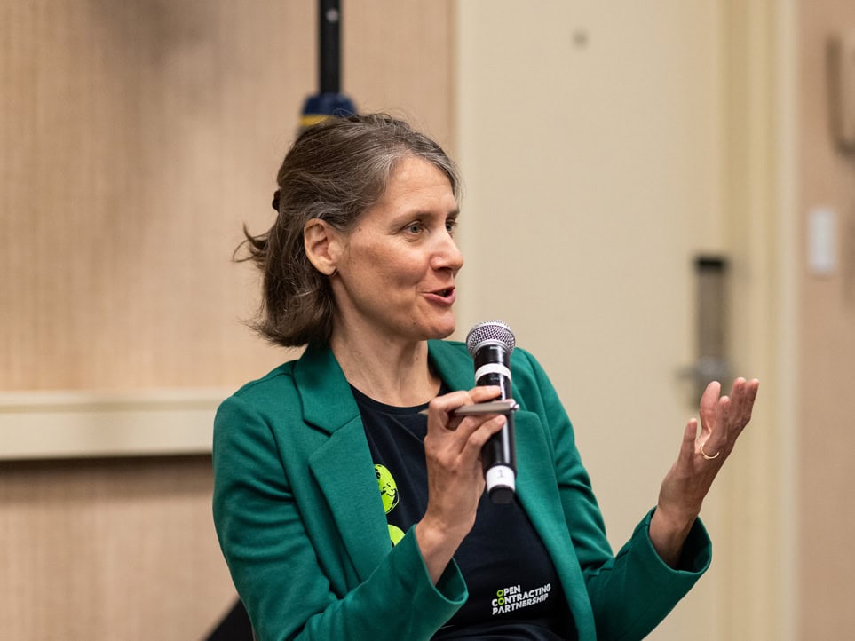 A speaker with a microphone speaking at Code for America Summit 2024