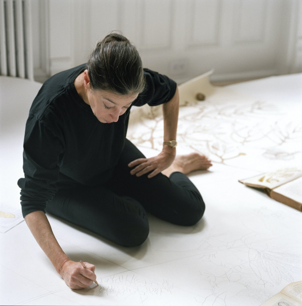 Color photograph of Michele Oka Doner drawing on the floor