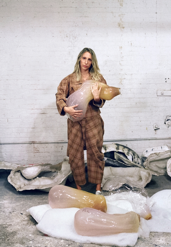 Color photographic portrait of Ivana Bašić cradling ovoid blown glass object