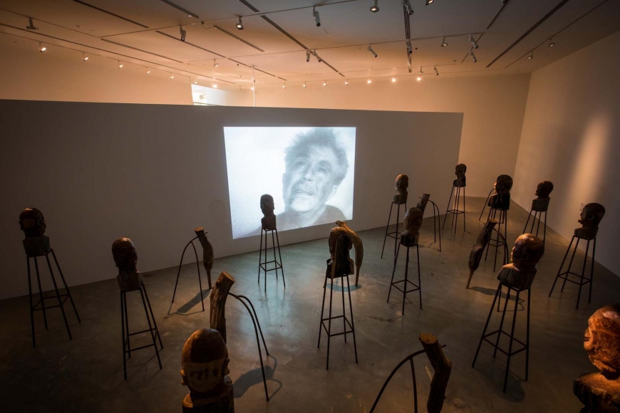 Kader Attia, J’Accuse, 2016, installation view, Kader Attia, Museum of Contemporary Art Australia, Sydney, 2017, teak, steel rebar, single-channel digital video, projection, colour, sound, courtesy the artist and Galerie Nagel Draxler, Berlin/Cologne, image courtesy the artist and Museum of Contemporary Art Australia © the artist, photograph: Anna Kučera