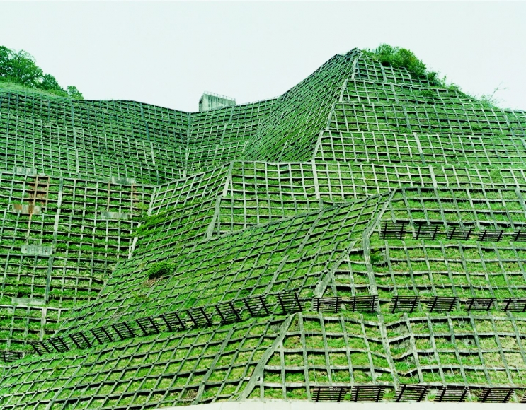 photo of grassy hill with architecture by thomas fletchner