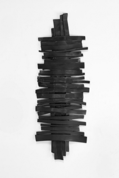 a bronze wall sculpture of horizontal strips overlaying a vertical strip by anthony pearson