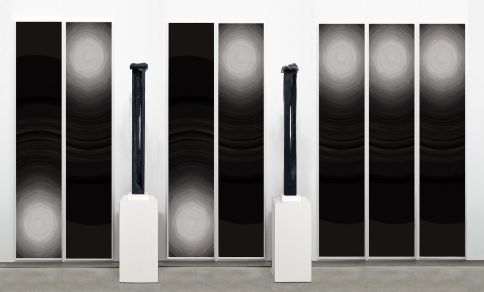 arrangement by anthony pearson with two black rectangular sculptures and six paintings