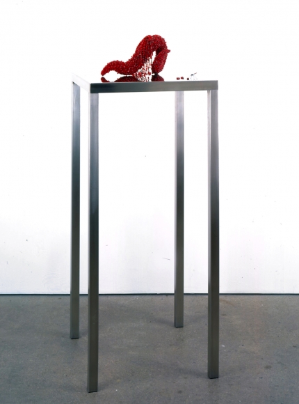 Black table with red sculpture by Angelo Filomeno