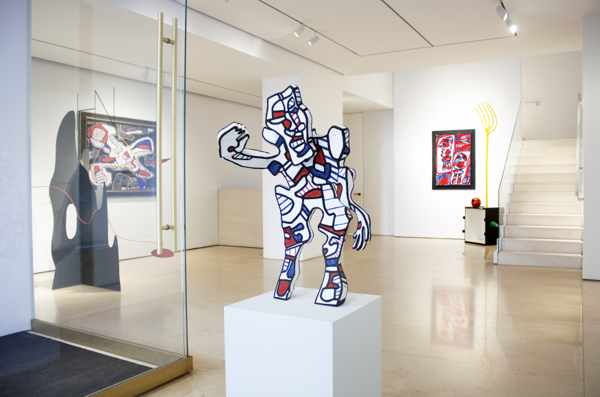 This is a general view of the lobby entrance of Helly Nahmad Gallery featuring a sculpture by Dubuffet in the front and one of Dubuffet's painting in the background and a sculpture by Joan Miro. On the left side we can see a large sculpture by Calder and another Dubuffet painting next to it.