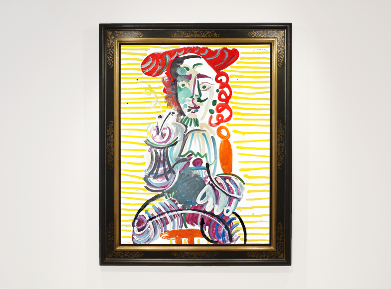 Installation image of Pablo Picasso's painting "L'Homme a la pipe" (the man with the pipe) made in 1968. It is a portrait of a man seating on a stool holding a pipe, wearing a red hat. The background is vibrant and achieved with horizontal yellow stripes.