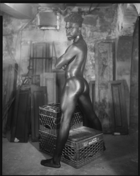 Man standing over milk crates by Benjamin Fredrickson