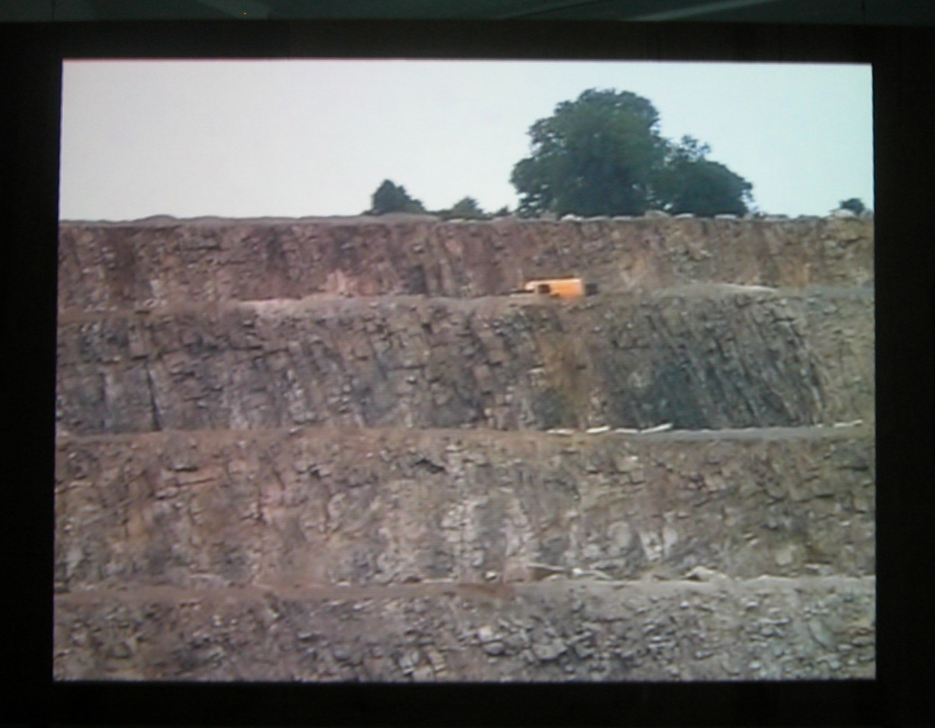 Quarry, 2003 (still), Two Parts: “Blast” (4 minutes), “Dr. Chris Alabaster” (12 minutes), 2 DVDs, bleachers, wooden screen, Installation dimensions variable
