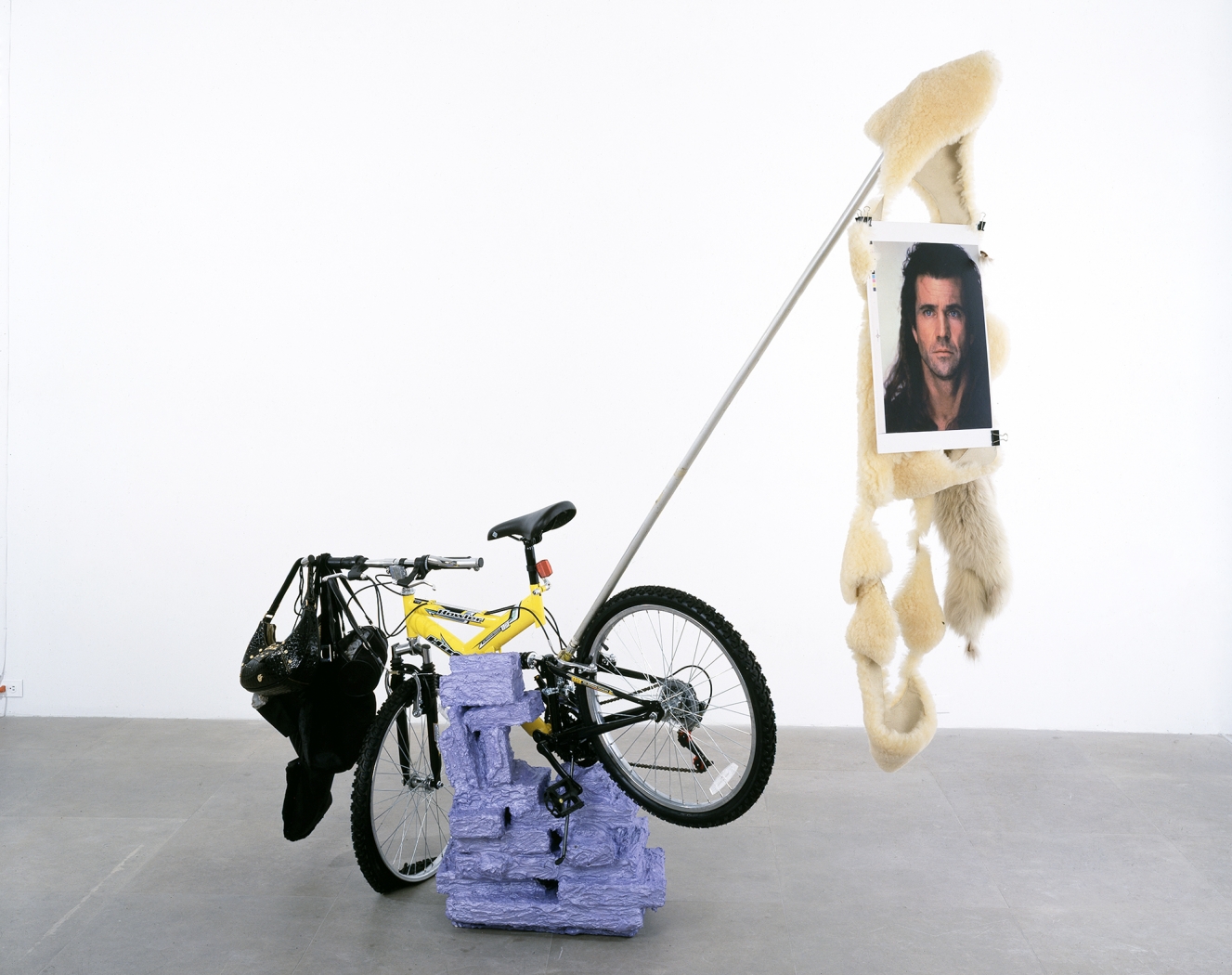 Rachel Harrison Huffy Howler, 2004 Wood, polystyrene, cement, acrylic, Huffy Howler bicycle, handbags, rocks, brick, sheepskin fur, metal pole, wire, pigmented inkjet print, binder clips 84 x 84 x 30 inches (213.4 x 213.4 x 76.2 cm)