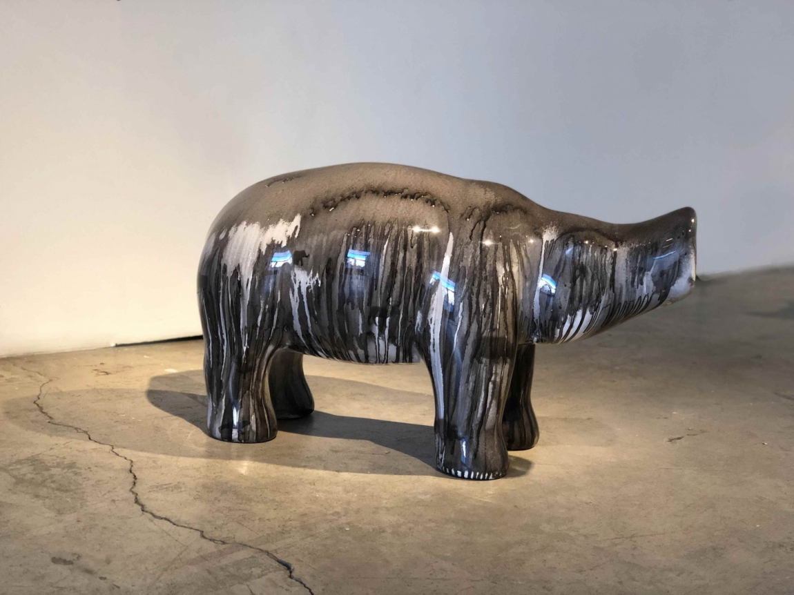 Boar sculpture covered in dripping paint.