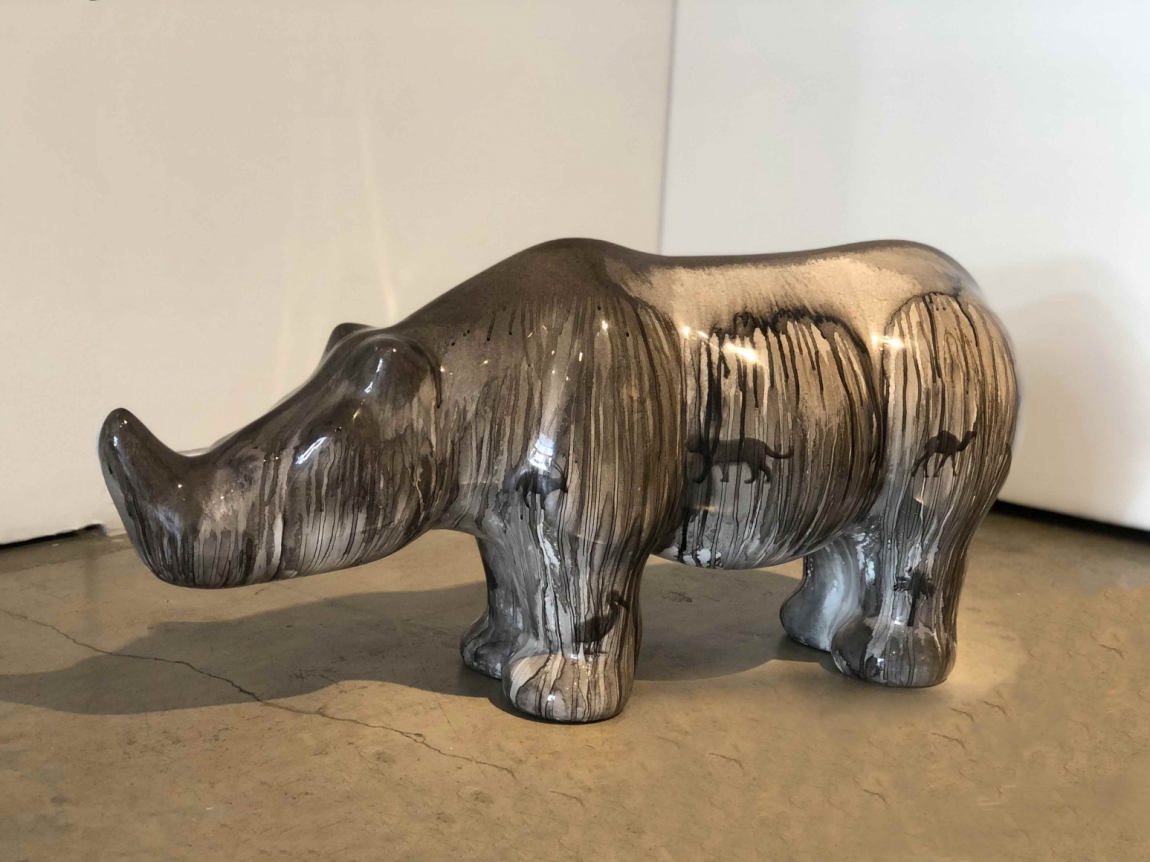 Rhino sculpture covered in dripping paint.