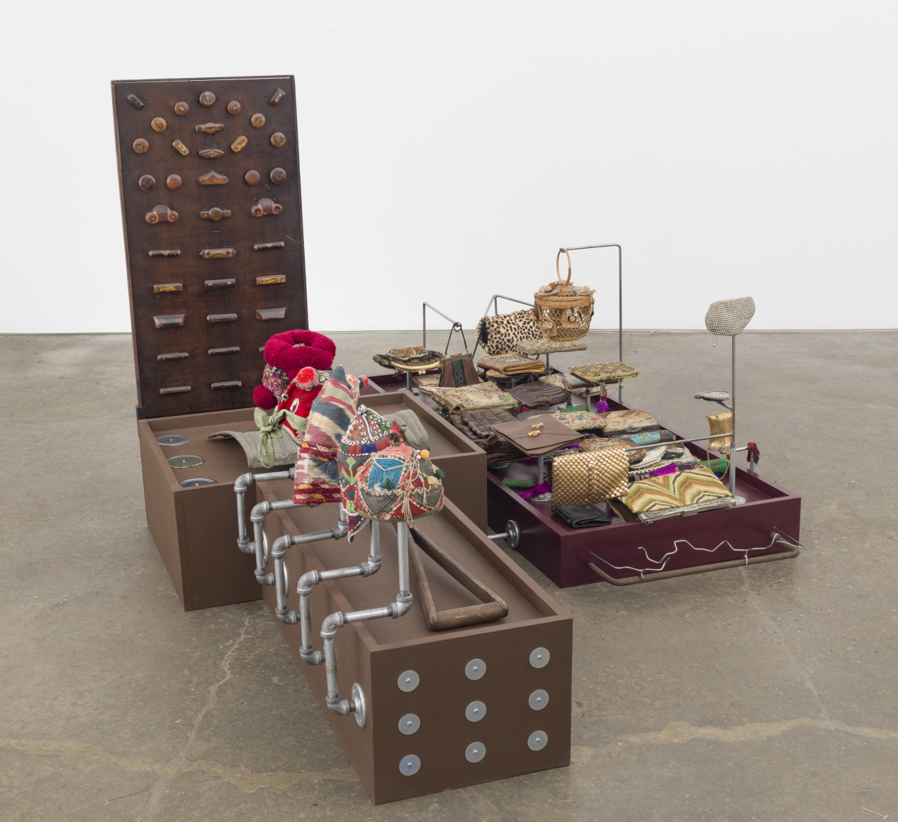 Collections - Love and work, 2017-18, collection of evening bags, handmade snow shovel, baby hats (China, Afghanistan, Uzbekistan), panel of drawer knobs, tin can covers, metal rods, plumbing parts, wooden platforms