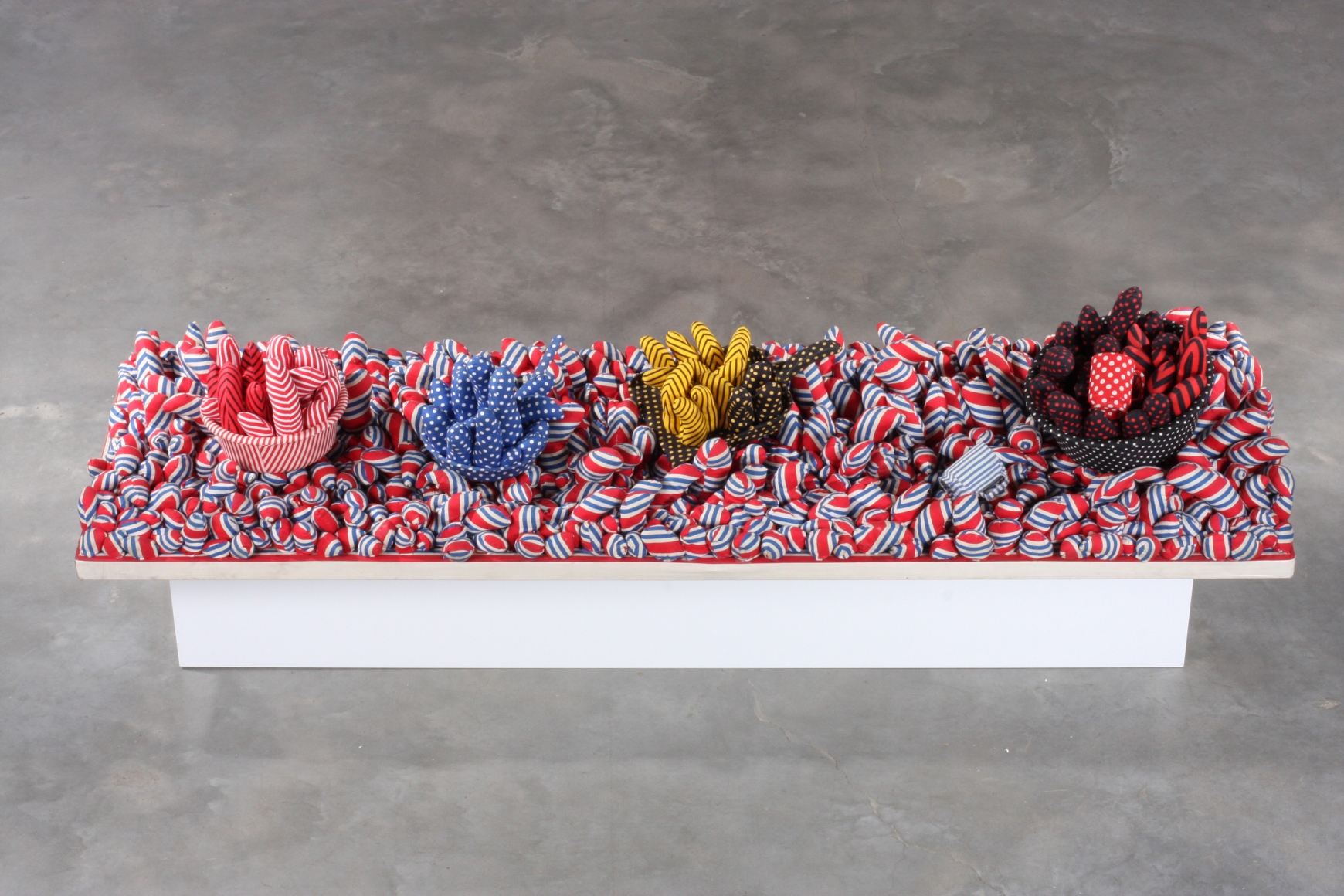 red, blue, and yellow plush sculpture by yayoi kusama