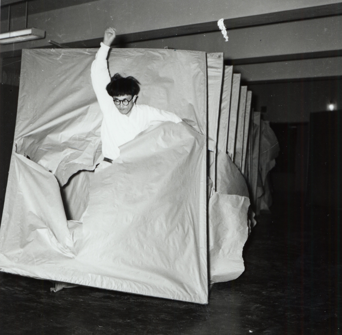 photograph of a man running through a structure by saburo murakami