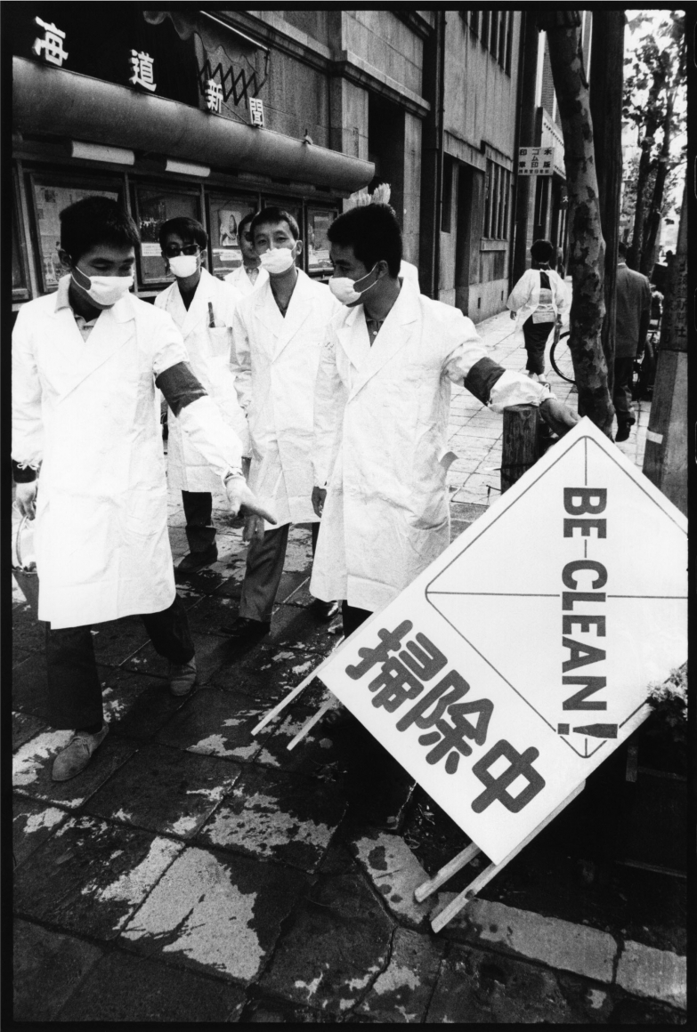 photograph of men in lab coats with "be clean" poster by minoru hirata