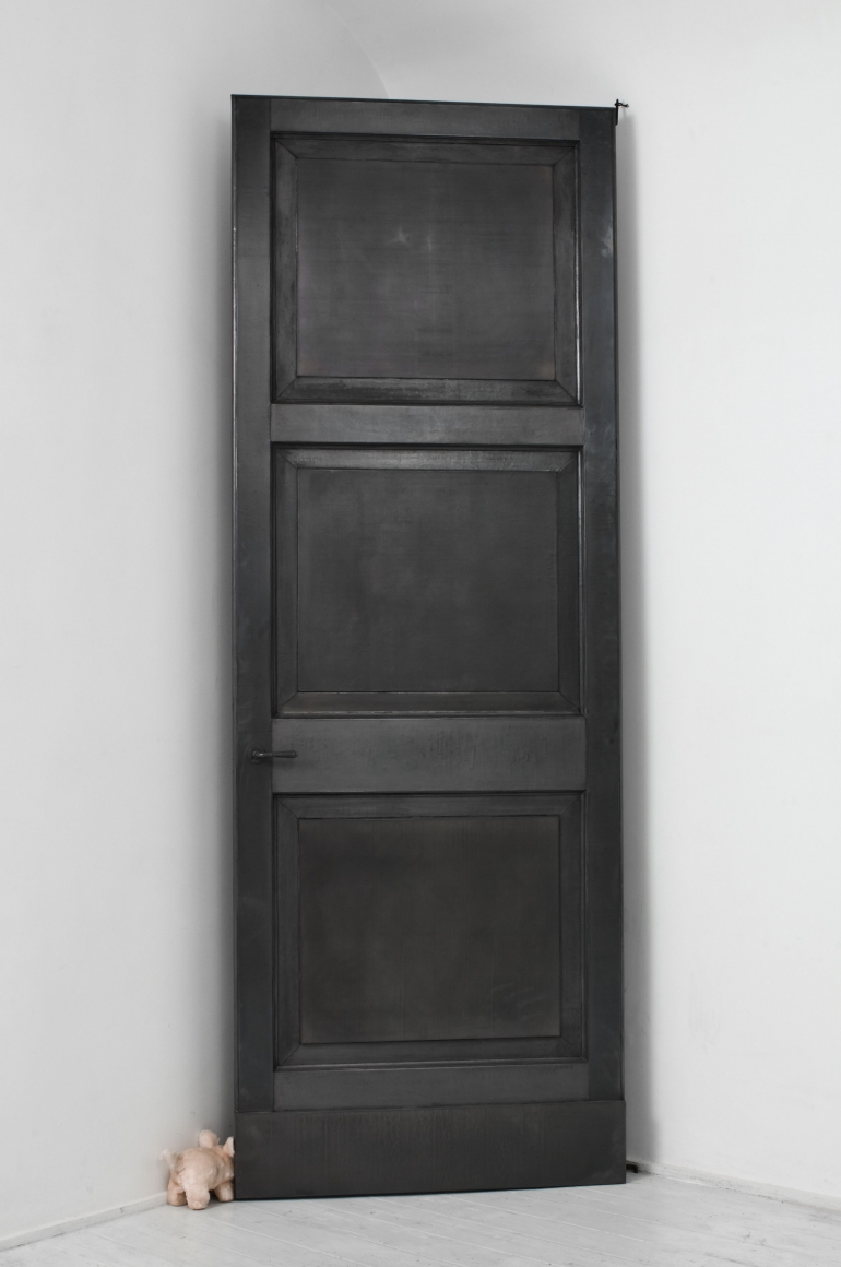 black door with small toy by pier paolo calzolari