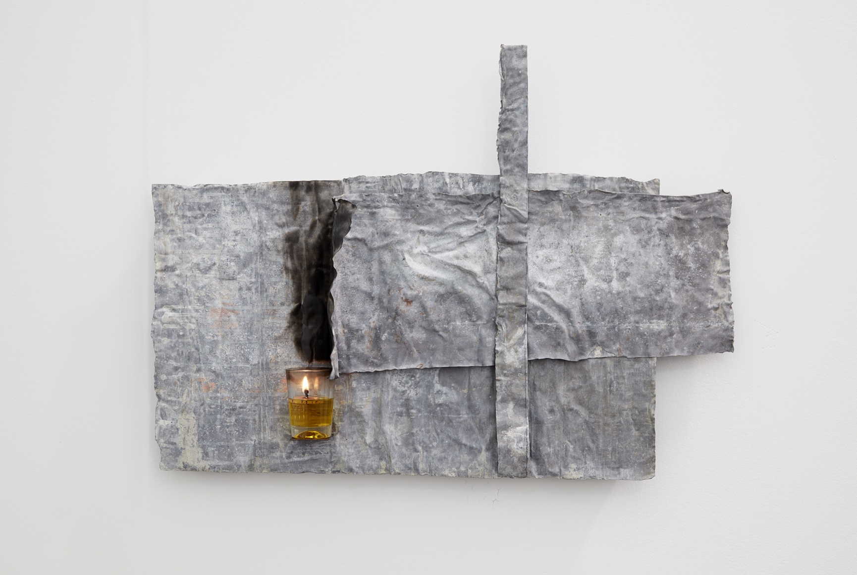 a lead and candle work of art by Italian artist Pier Paolo Calzolari