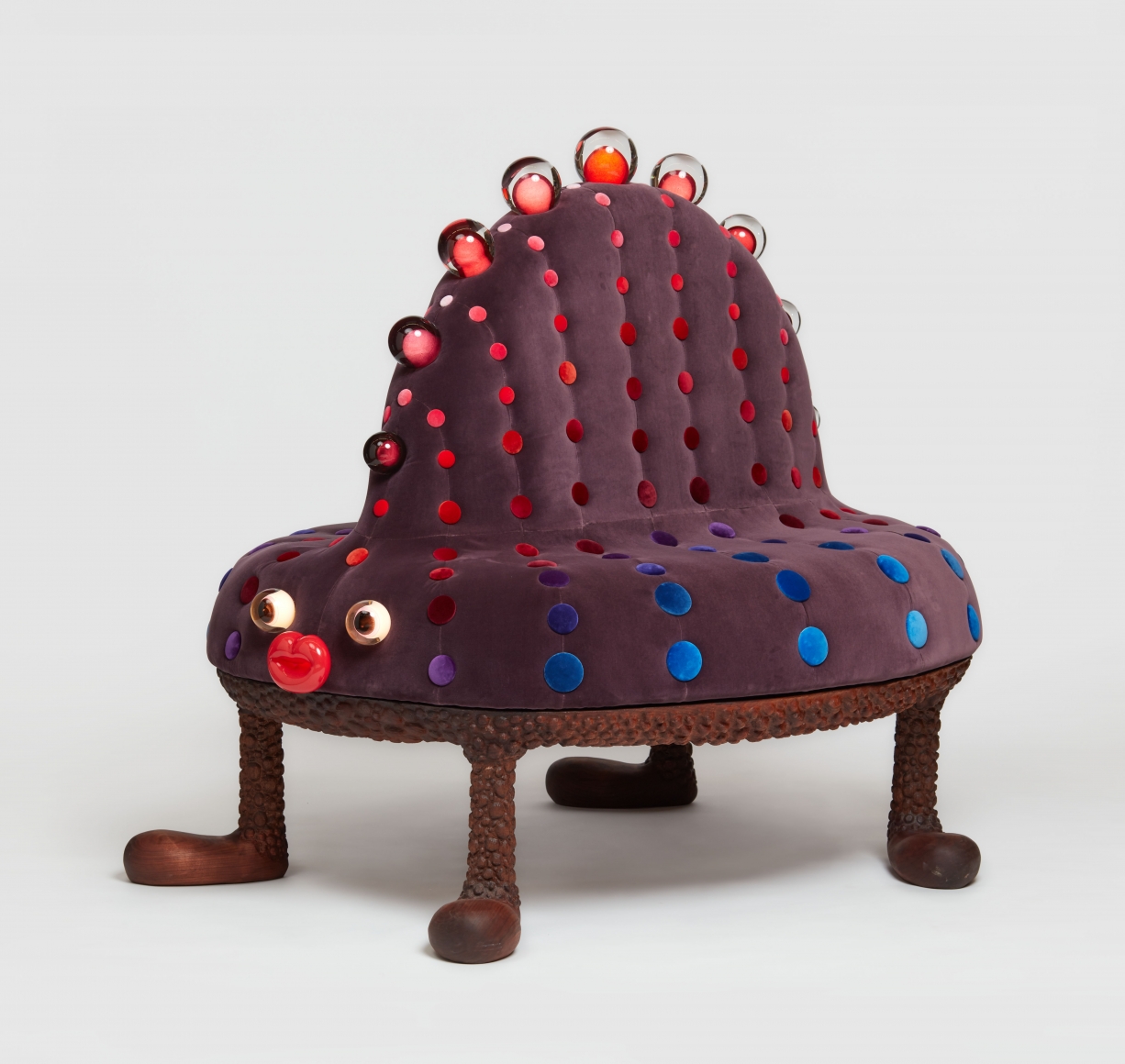 Purple four legged bench sculpture with light up eyes and back spine by the artists the haas brothers