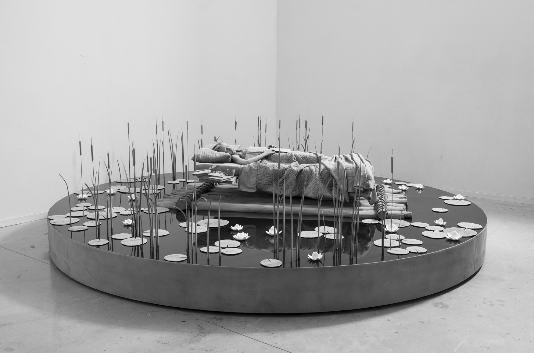 sculpture of a young girl in a pond by Hans Op de Beeck