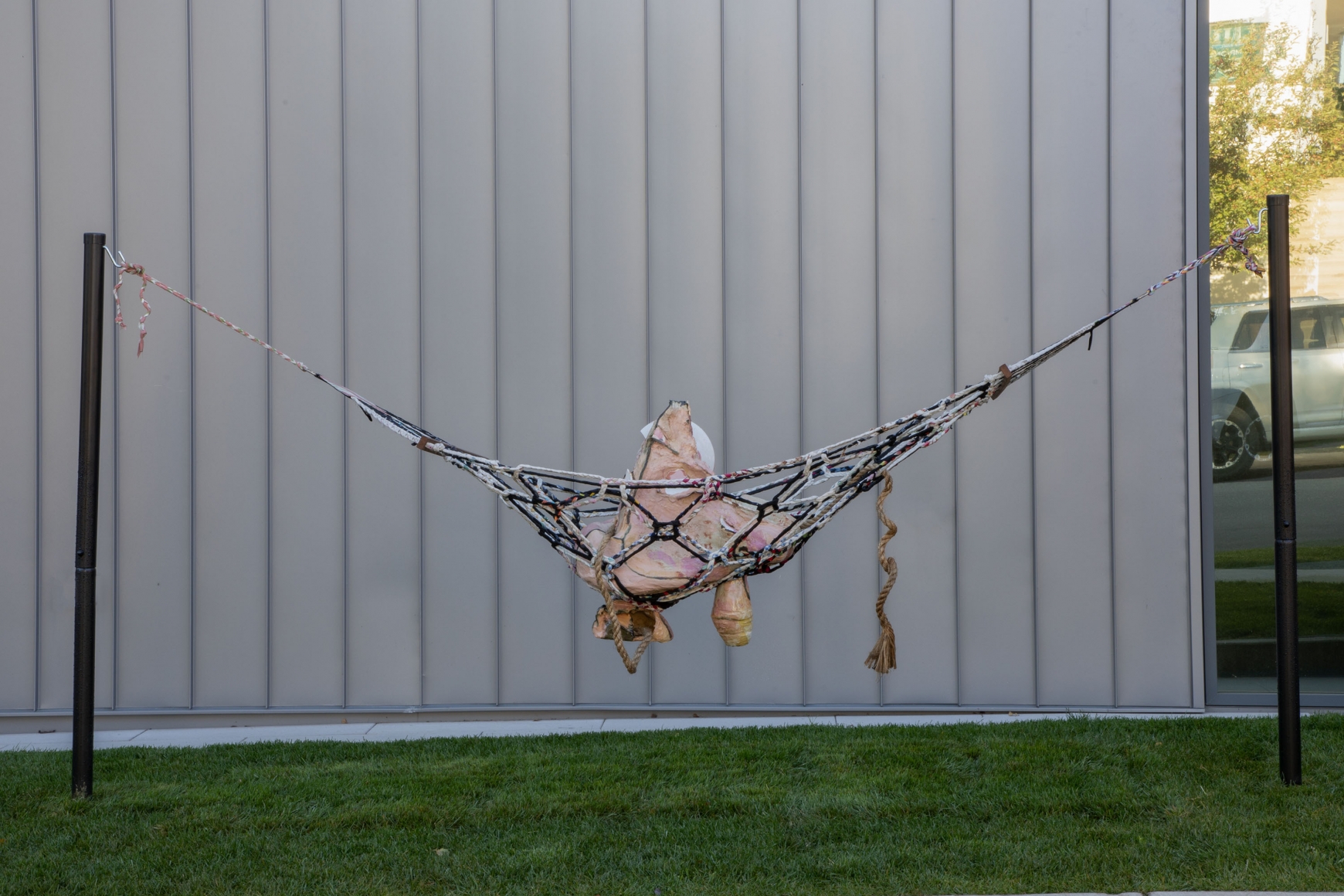 a ceramic artwork in a hammock that is exhibited outdoors by jessica jackson hutchins