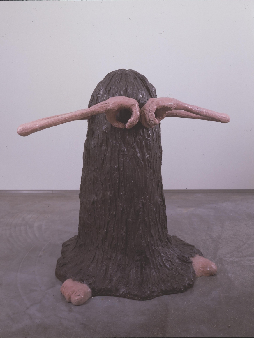sculpture of a hairy creature with hands covering his eyes