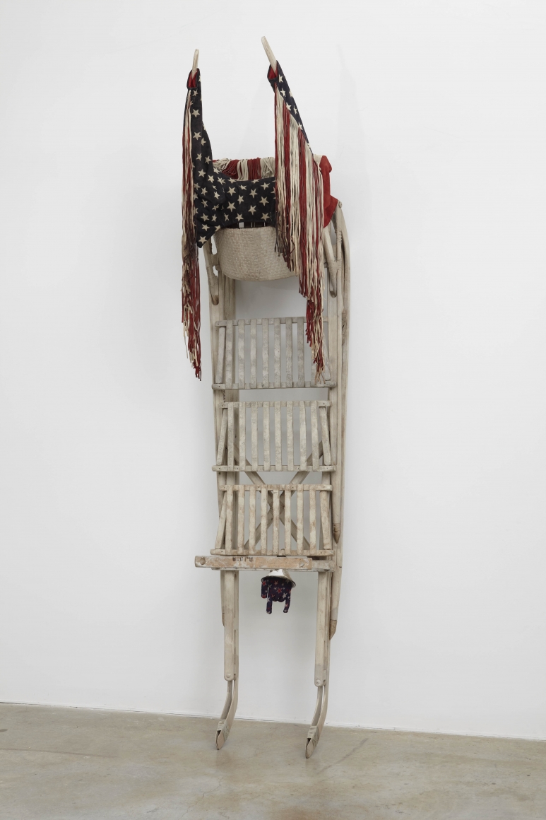 a sled with american flags by salvatore scarpitta on exhibition in a new york city gallery