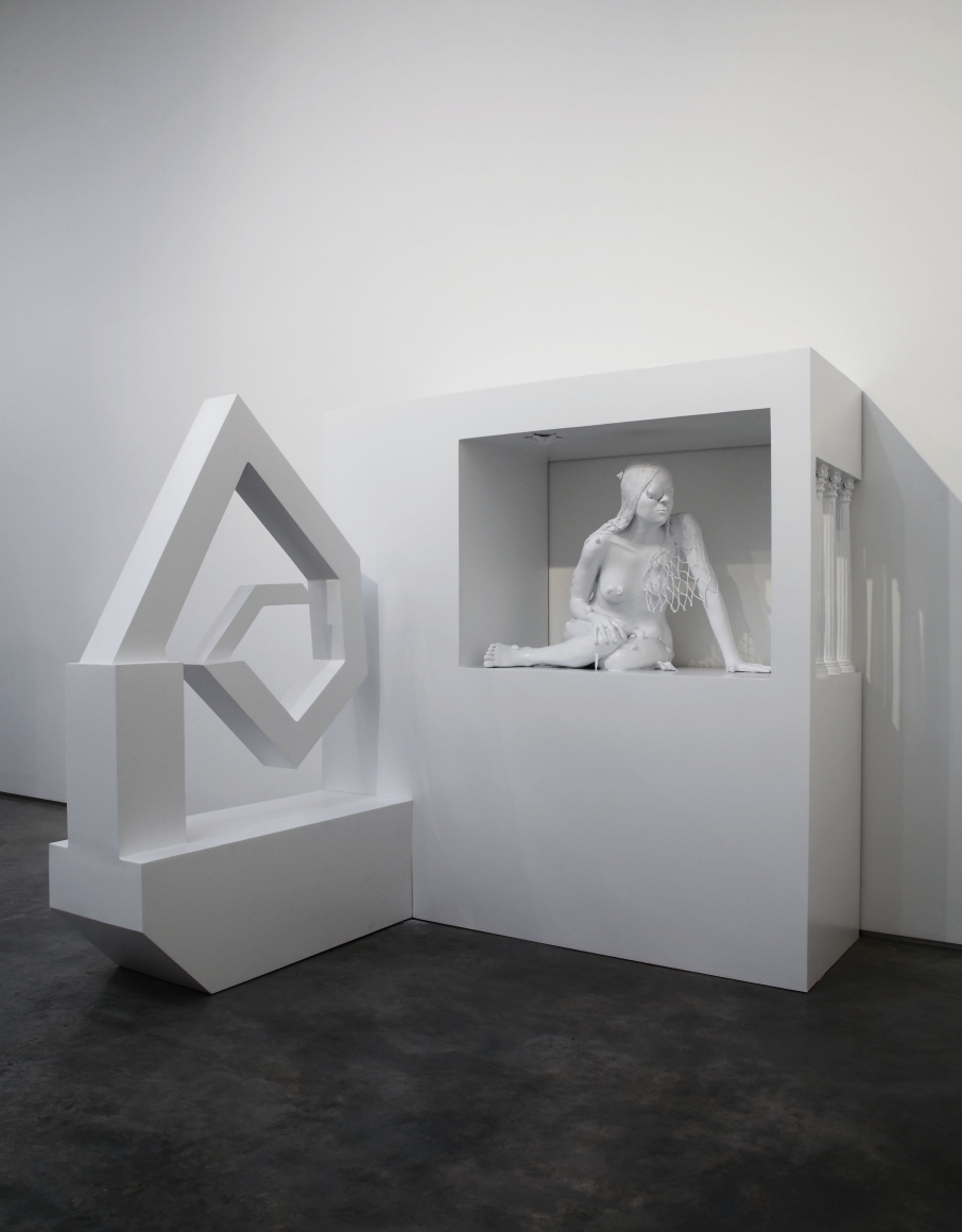 sculpture of a woman crouching in an enclosure by liz craft