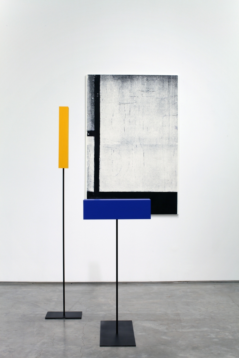 installation by melissa gordon with black and white grid painting and blue and yellow rectangular sculptures