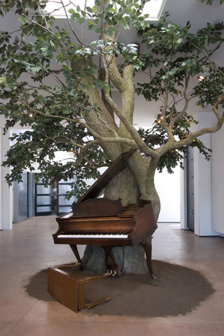 An installation of a piano and a steel sculpture tree created by the artist Sanford Biggers