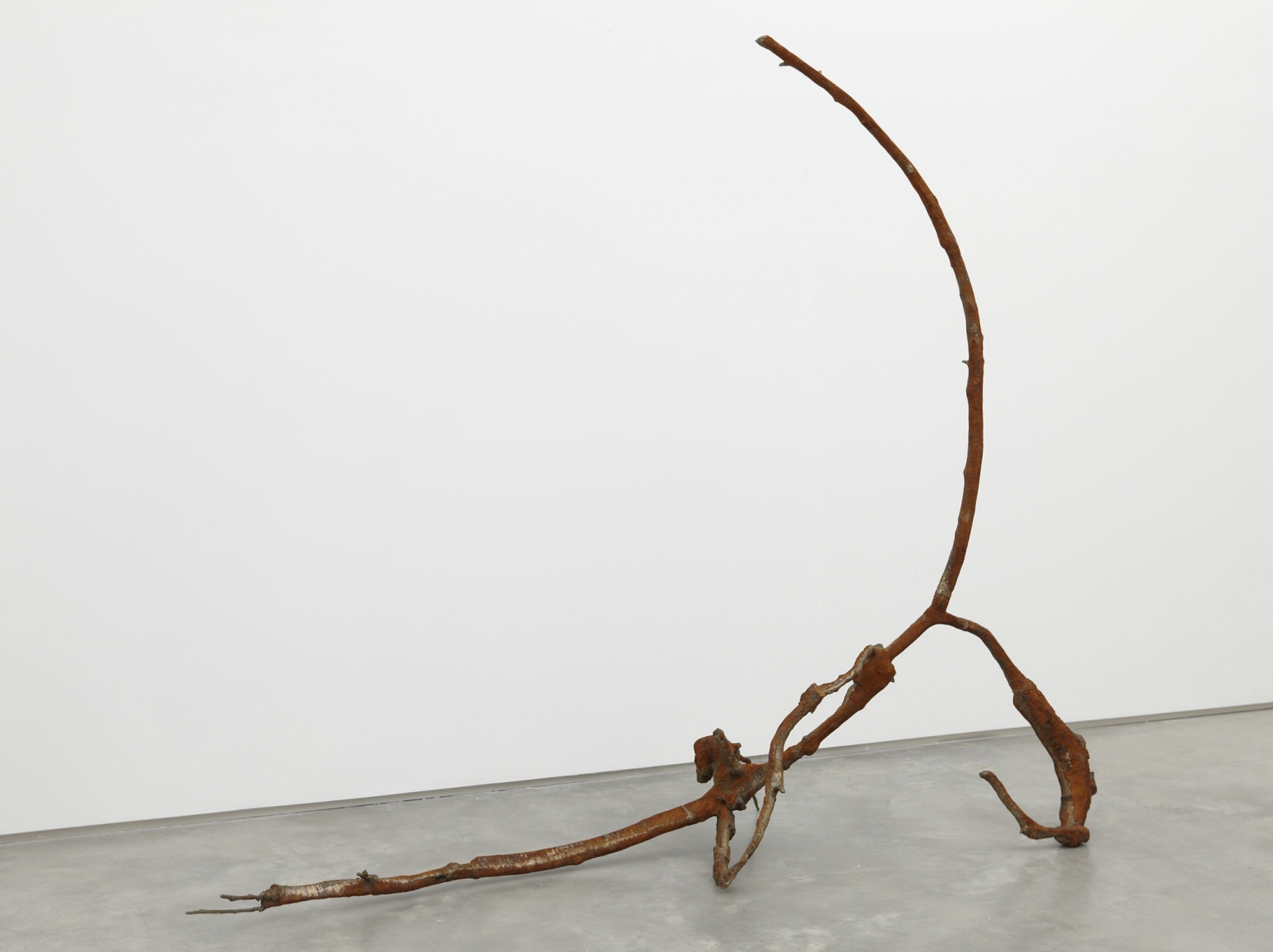 a rusted iron and bronze abstract sculpture by jay heikes exhibited in a nyc gallery