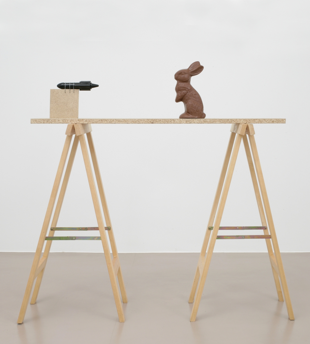 installation by roman signer featuring a rocket aimed at a chocolate easter bunny